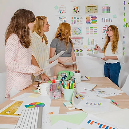 A diverse group of women gathered around a table with documents, showcasing their essential participation in the economy.